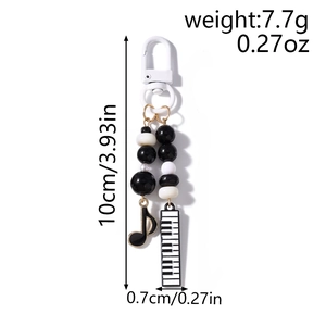 Detail of music phone strap with dimensions and weight showing piano and note charms
