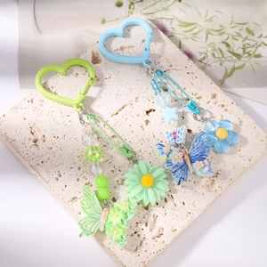 Porte-clés en perles faits main avec papillons et fleurs sur un support en pierre