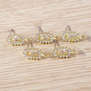 Vue détaillée de supports de boucles d'oreilles ovales dorés avec strass blancs pour DIY