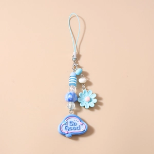 Detailed macro view of a blue beaded phone charm featuring SO GOOD cloud and flower beads