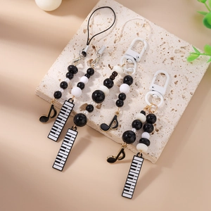 Fashionable music themed phone charm with black and white beads, piano keys and musical notes