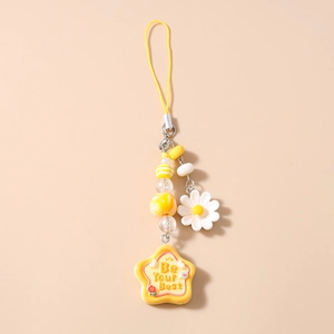 Detail of yellow beaded phone strap with daisy charm and star slogan pendant