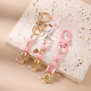 Detail view of pink beaded phone charms with gold accents and heart shaped metal pendants