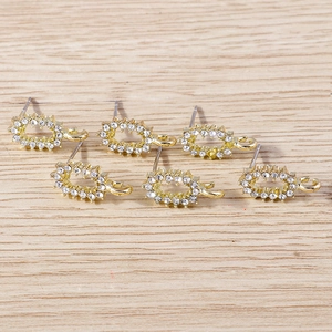 Détail de six boucles d'oreilles cœur dorées avec strass sur fond en bois clair