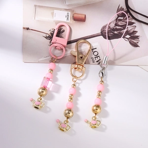 Pink beaded phone charm set with heart-themed teapot pendants and metal lobster clasps