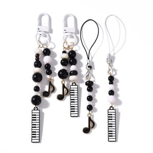 Black and white beaded phone charms with musical notes and piano keyboard pendants