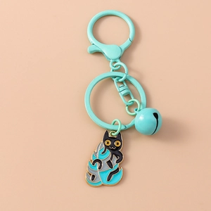 Detail of cartoon black cat keychain with mint green bell and leaf charm on enamel metal