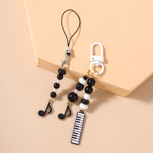 Detail of music themed phone strap and keychain with piano keys and musical notes