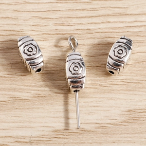 Vintage silver flower beads and pendant charms for DIY jewelry making on wood background