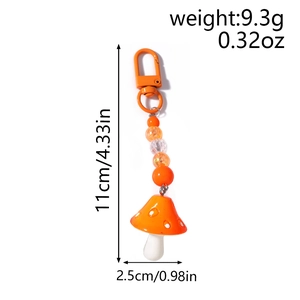 Detail view of orange mushroom keychain with striped beads and U-shaped metal clasp