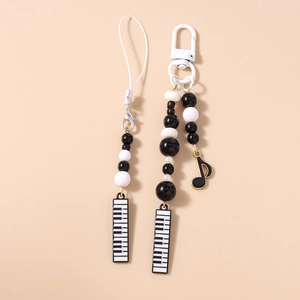 Detail of music themed phone strap and keychain with piano keys and musical notes