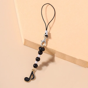 Detail view of black and white beaded phone strap featuring a musical note pendant