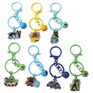 Set of 7 cartoon black cat enamel keychains with colorful bells and floral plant designs