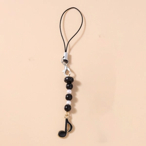 Detail of music-themed phone charm featuring black beads and a gold-trimmed note pendant