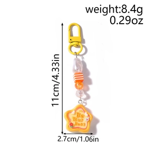 Detail view of yellow star keychain with Be Your Best slogan and striped beads