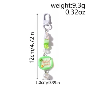 Detail of beaded keychain with green striped beads and Good Luck tag, length 12cm