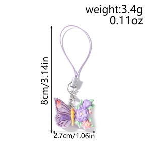 Detailed view of a purple butterfly phone charm with resin flowers and lobster clasp