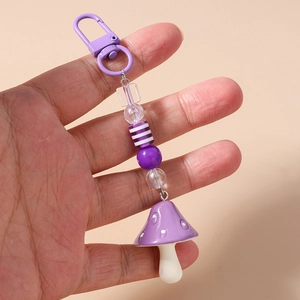 Close-up of purple mushroom charm keychain with beaded chain and metal carabiner hook