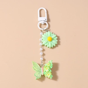 Detail von Macaron-Gänseblümchen und Blumen-Schmetterling-Schlüsselanhänger mit Perlen