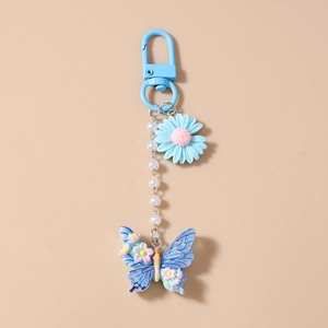 Detailansicht von hellblauem Gänseblümchen- und Schmetterlingsanhänger mit Perlenkette