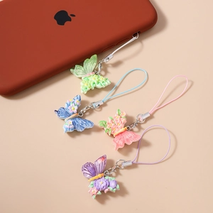Detailed view of colorful butterfly phone charms with embossed floral resin patterns