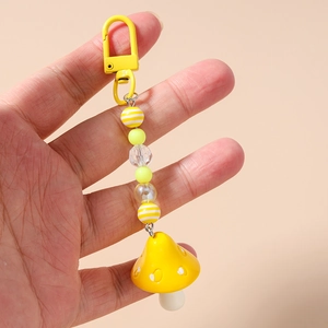 Detail of yellow mushroom keychain featuring striped beads and metal lobster clasp