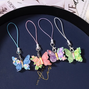 Detailed close-up of colorful resin butterfly and floral pendants on woven phone straps