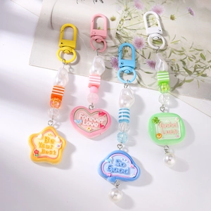 Detail of colorful beaded keychains with faux pearls and heart-shaped charms with text
