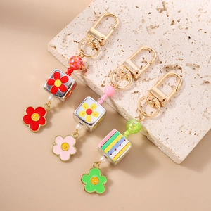 Portachiavi con margherite di perline, fiori smiley e perle a cubo con gancio dorato