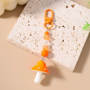 Close-up of orange mushroom beaded keychain with resin charms and alloy lobster clasp