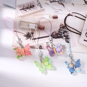 Detailed close-up of colorful resin butterfly charms with small flowers and metal clasps