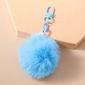 Détail du porte-clés pompon en fausse fourrure bleu vif avec son fermoir assorti