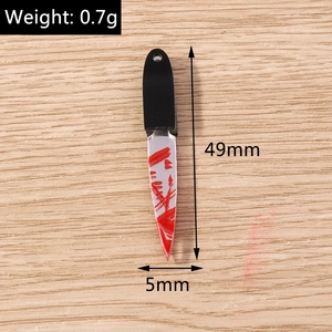Macro shot of 49mm miniature acrylic cleaver charms with red blood splatter and hole detail