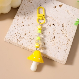 Detail of yellow mushroom keychain with striped beads and metallic lobster clasp hook