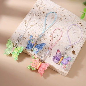 Detail showing four colorful butterfly phone charms with 3D flower craft and metal clasps