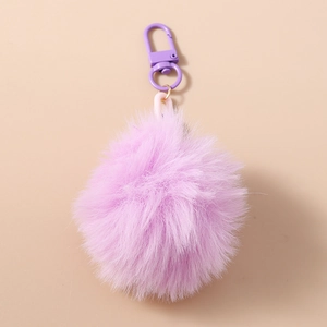 Détail du porte-clés pompon en fausse fourrure violette avec mousqueton et anneau rose