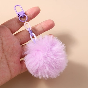 Vue détaillée du porte-clés pompon violet en fausse fourrure avec chaîne pastel