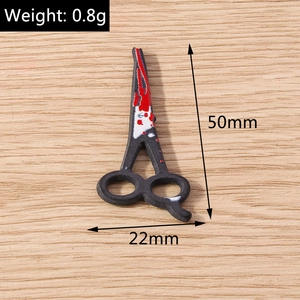 Macro shot of 50mm horror scissors charm with red blood splatter and dimension markers