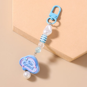 Detailed shot of a blue striped beaded keychain with a pearl and So Good cloud charm