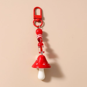 Detail of red mushroom keychain with striped acrylic beads and heart charm