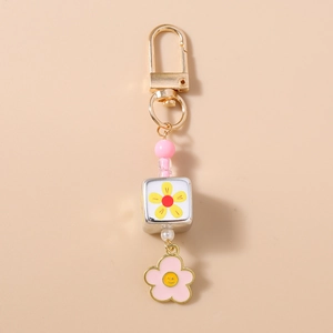 Dettaglio del ciondolo a fiore rosa con smiley e perla a margherita del portachiavi