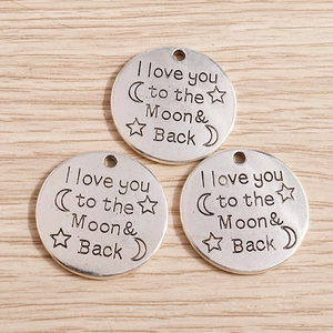 Detail view of silver moon star pendants engraved with I love you to the Moon and Back