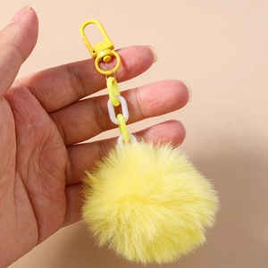 Gros plan d'un porte-clés en fausse fourrure jaune citron avec un fermoir en métal robuste