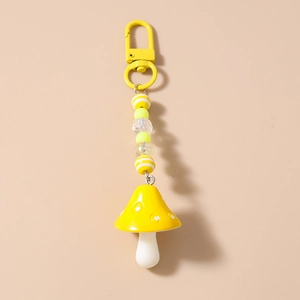 Close-up of a vibrant yellow mushroom keychain with striped beads and a metal clasp