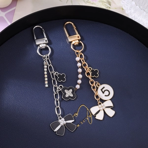 Elegant pearl and floral charms keychain set with tassels and bows in gold and silver finish