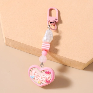 Detail of pink keychain featuring striped cube bead and heart pendant with Forever Love text