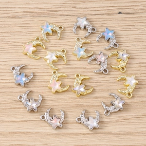 Macro detail of star and moon charms with opal-like stones on light wood surface