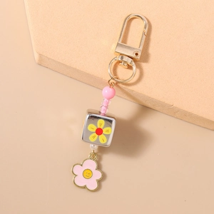 Dettaglio portachiavi rosa con perline e ciondoli a forma di margherita sorridente