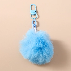 Détail d'un porte-clés pompon en fausse fourrure bleu clair avec fermoir mousqueton assorti