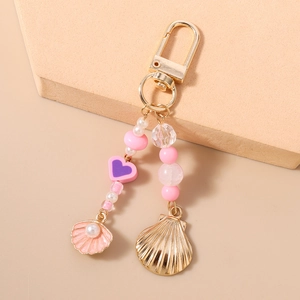 Detail view of heart beaded keychain with seashell pendants and golden lobster clasp